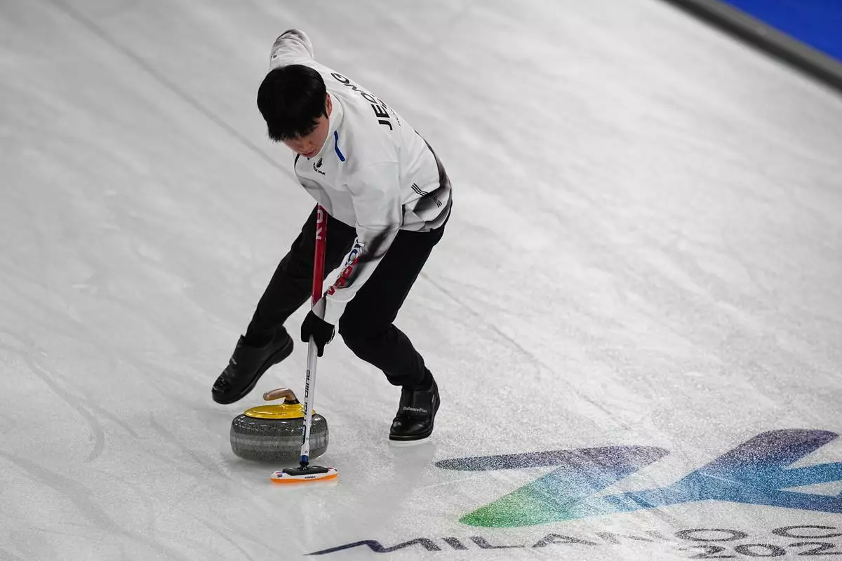 South Korea's Yeongseok Jeong sweeps a stone, during the mixed doubles round robin phase of the curling competition against Sweden, at the 2026 Winter Olympics, in Cortina d'Ampezzo, Italy, Wednesday, Feb. 4, 2026. (AP Photo/Fatima Shbair)
