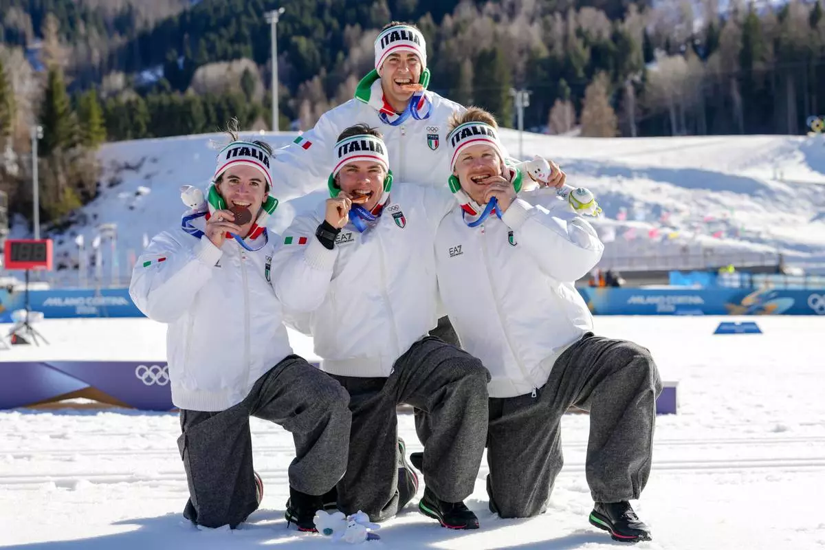 Davide Graz, Elia Barp, Martino Carollo and Federico Pellegrino, of Italy, pose after winning the bronze medal in the cross country skiing men's 4 x 7.5km relay at the 2026 Winter Olympics, in Tesero, Italy, Sunday, Feb. 15, 2026. (AP Photo/Kirsty Wigglesworth)