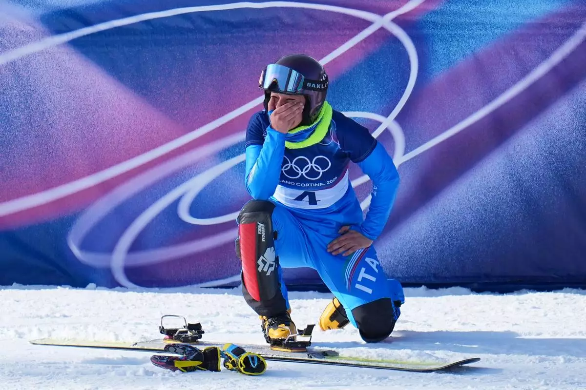 Italy's Lucia Dalmasso celebrates winning the bronze medal against Italy's Elisa Caffont during the women's snowboarding parallel giant slalom finals at the 2026 Winter Olympics, in Livigno, Italy, Sunday, Feb. 8, 2026. (AP Photo/Gregory Bull)