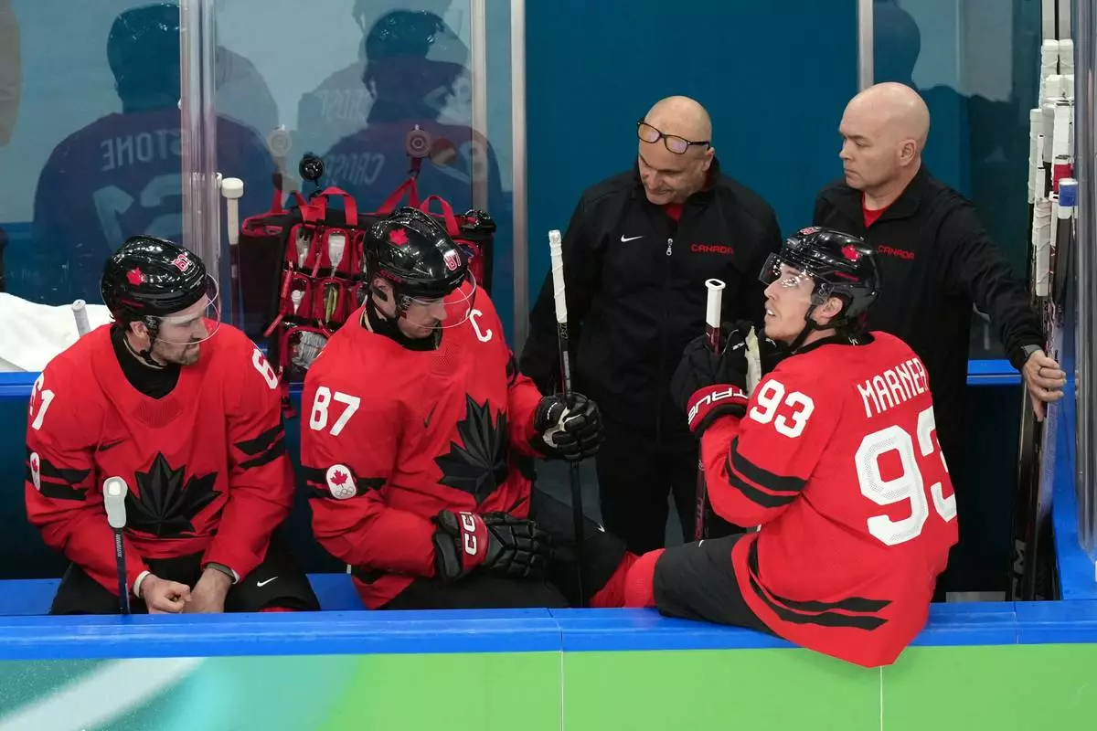 Canada's Sidney Crosby (87) is attended to after being injured during the second period of a men's ice hockey quarterfinal game between Canada and Czechia at the 2026 Winter Olympics, in Milan, Italy, Wednesday, Feb. 18, 2026. (AP Photo/Hassan Ammar)