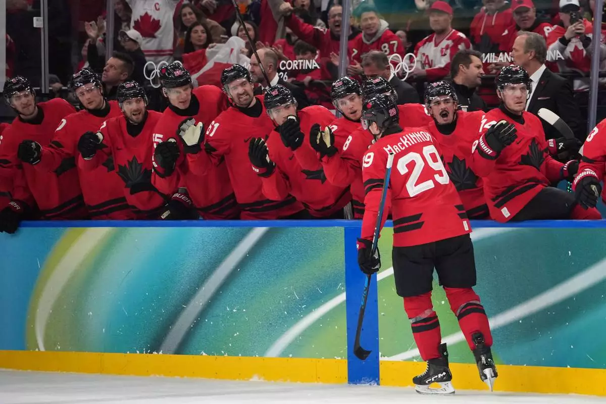 Canada's Nathan MacKinnon (29) is congratulated after scoring a goal against Czechia during the second period of a men's ice hockey quarterfinal game at the 2026 Winter Olympics, in Milan, Italy, Wednesday, Feb. 18, 2026. (AP Photo/Carolyn Kaster)