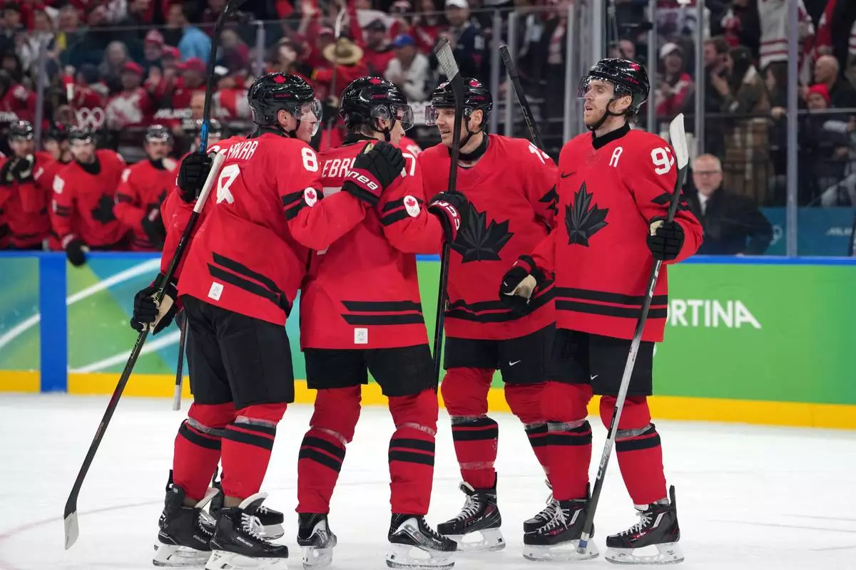 Team Canada players celebrate after a goal by Nathan MacKinnon during the second period of a men's ice hockey quarterfinal game against Czechia at the 2026 Winter Olympics, in Milan, Italy, Wednesday, Feb. 18, 2026. (AP Photo/Carolyn Kaster)