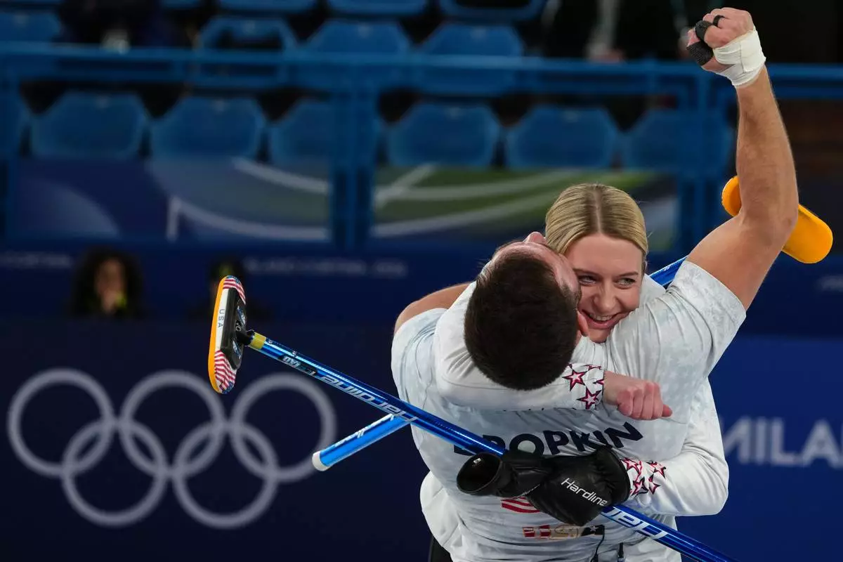 United States' Cory Thiesse and Korey Dropkin hug during the mixed doubles round robin phase of the curling competition against Sweden, at the 2026 Winter Olympics, in Cortina d'Ampezzo, Italy, Sunday, Feb. 8, 2026. (AP Photo/Misper Apawu)