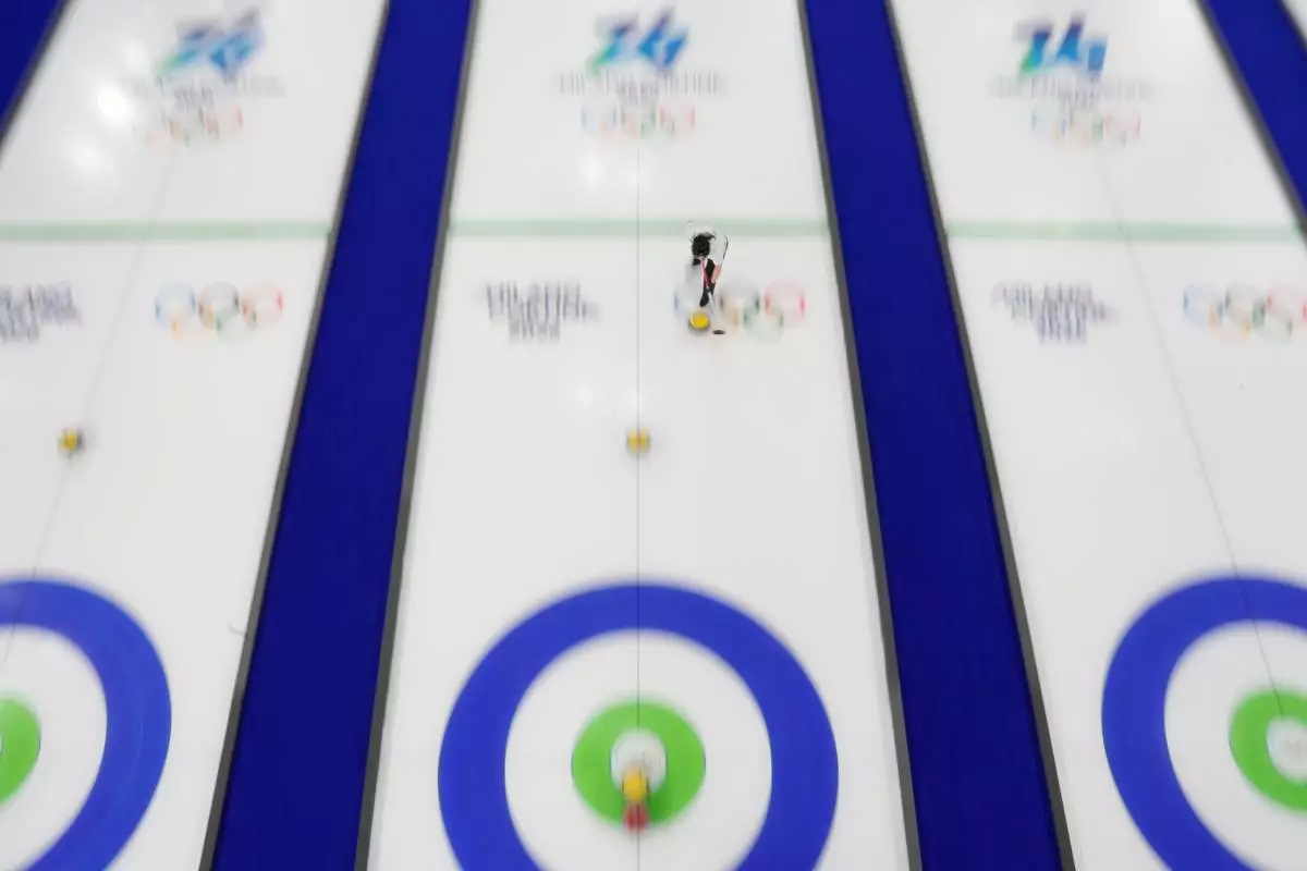 South Korea's Kim Seon-yeong sweeps in front of a stone while competing during a curling mixed doubles round robin session against Estonia at the 2026 Winter Olympics, in Cortina d'Ampezzo, Italy, Sunday, Feb. 8, 2026. (AP Photo/David J. Phillip)