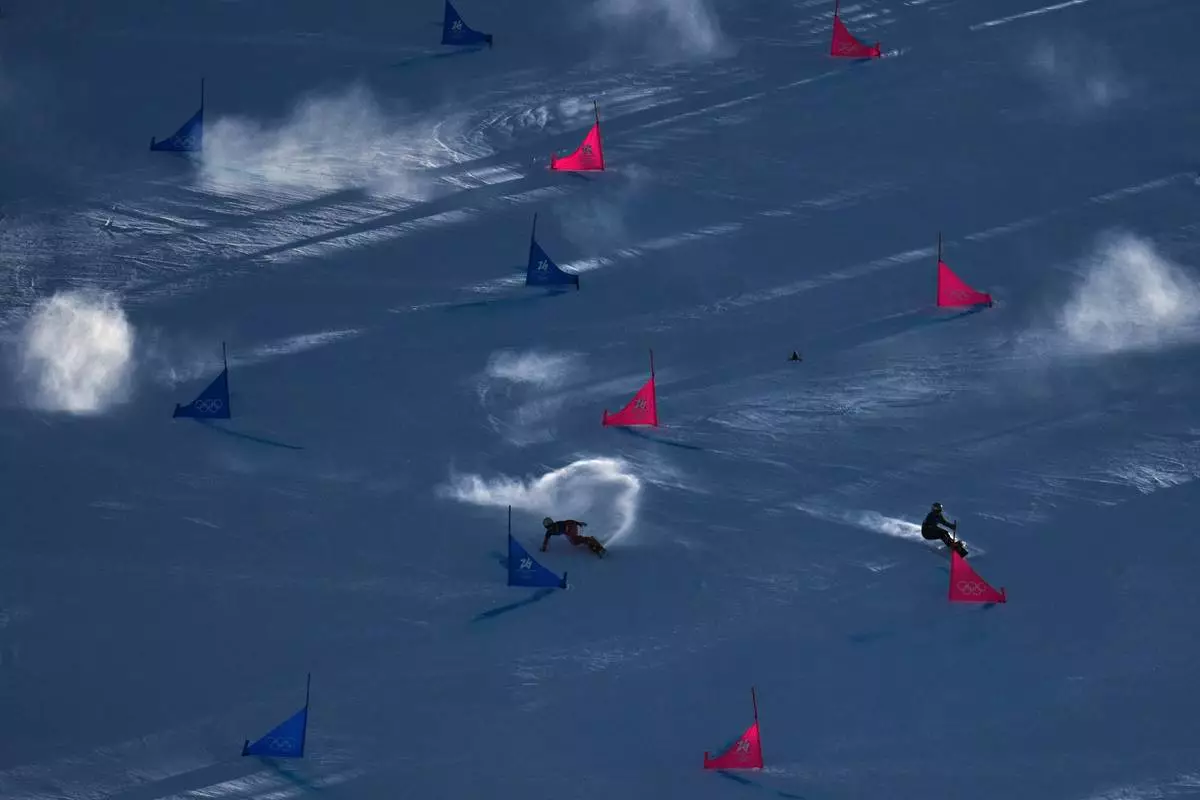 Switzerland's Ladina Caviezel, left, and compete Ukraine's Annamari Dancha during the women's snowboarding parallel giant slalom qualifications at the 2026 Winter Olympics, in Livigno, Italy, Sunday, Feb. 8, 2026. (AP Photo/Abbie Parr)