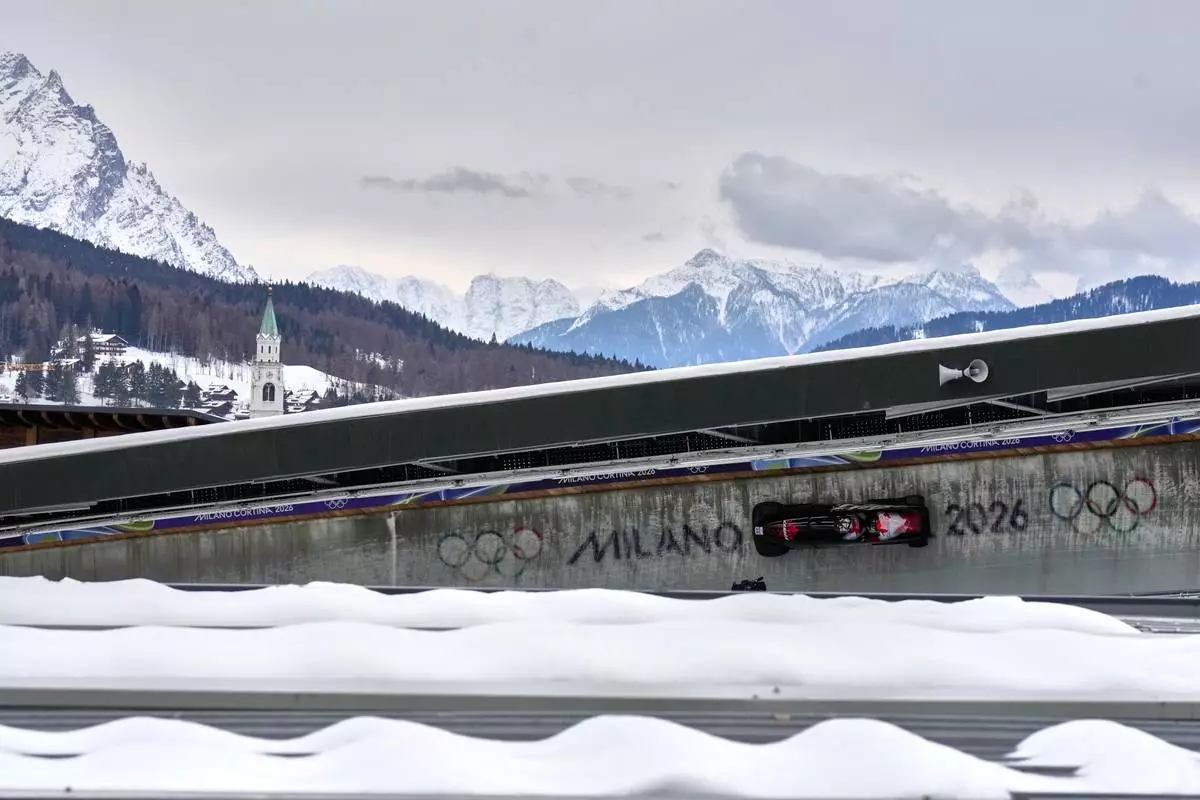 Canada's Taylor Austin, front, and Shaquille Murray-Lawrence slide down the track during a two man bobsled run at the 2026 Winter Olympics, in Cortina d'Ampezzo, Italy, Monday, Feb. 16, 2026. (AP Photo/Aijaz Rahi)