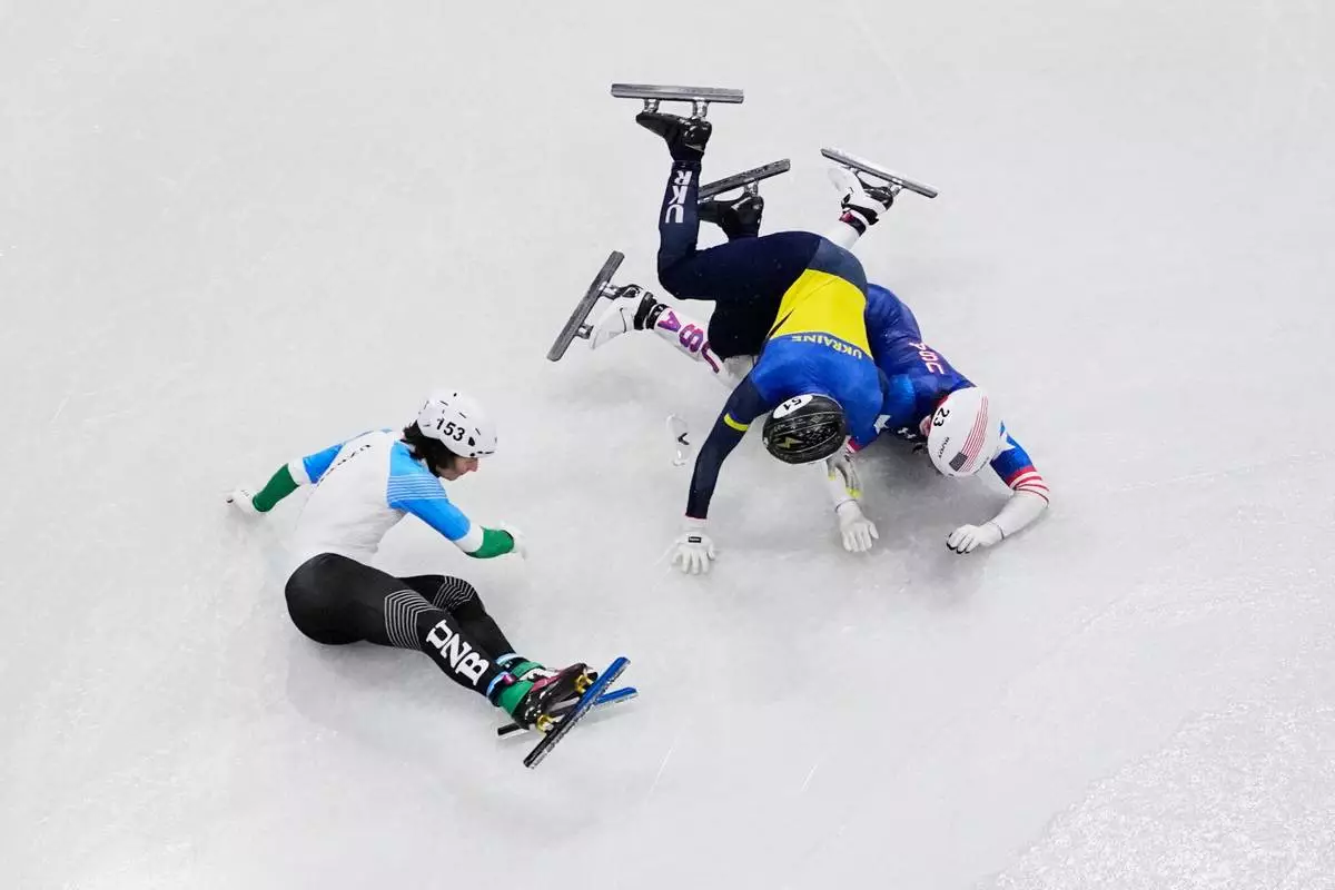 Brandon Kim of the United States, Oleh Handei of Ukraine and Daniil Eybog of Uzbekistan crash in the heats during the men's 500 meter short track speed skating at the 2026 Winter Olympics, in Milan, Italy, Monday, Feb. 16, 2026. (AP Photo/Bernat Armangue)