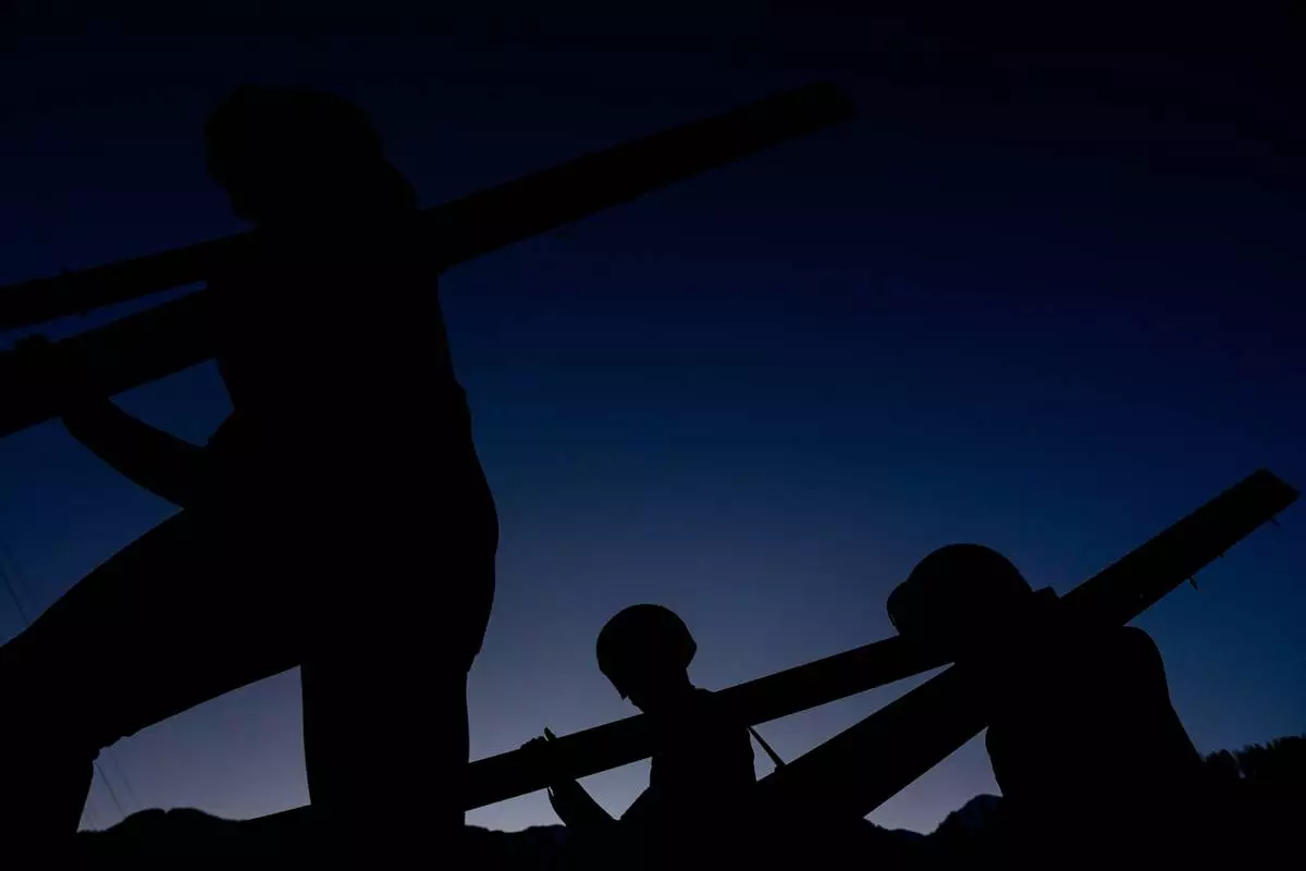 Athletes make their way to the ramp for their trial jump of the ski jumping men's super team competition at the 2026 Winter Olympics, in Predazzo, Italy, Monday, Feb. 16, 2026. (AP Photo/Matthias Schrader)