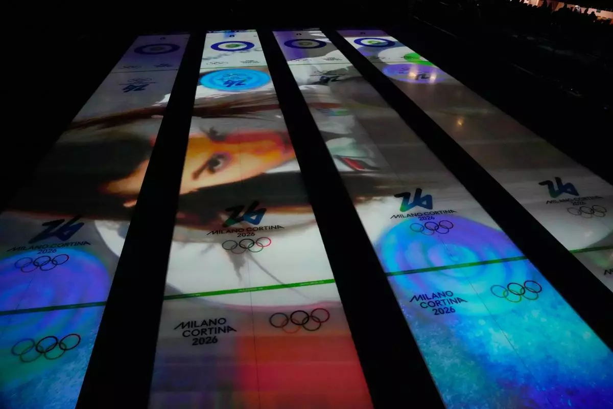Images are projected on the sheets of ice before a men's curling round robin session at the 2026 Winter Olympics, in Cortina d'Ampezzo, Italy, Monday, Feb. 16, 2026. (AP Photo/David J. Phillip)