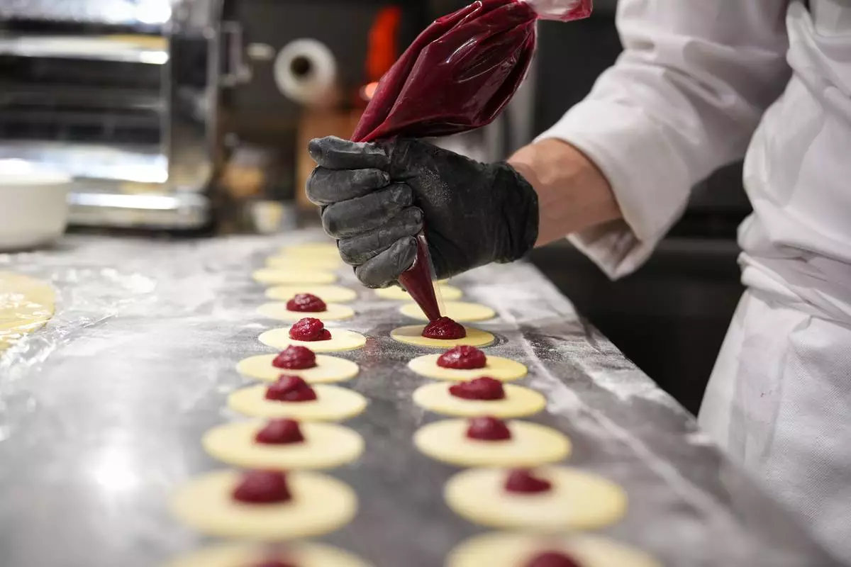 Local chef Gianluca Belli demonstrates how to make Casunziei, a type of ravioli that is Cortina's signature dish, during a pasta-making tutorial at a Michelin one-star restaurant in Cortina D'Ampezzo, Friday, Nov. 21, 2025. (AP Photo/Andrew Medichini)