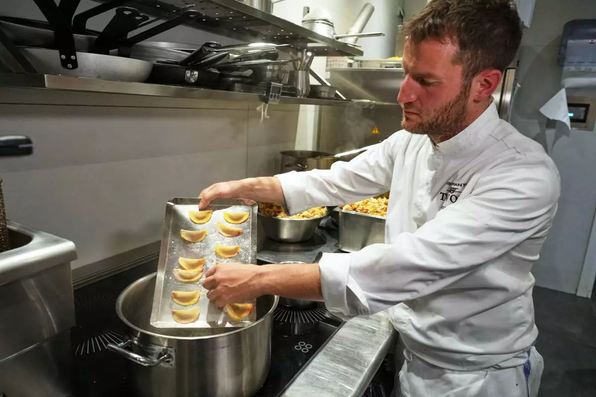 Local chef Gianluca Belli demonstrates how to make Casunziei, a type of ravioli that is Cortina's signature dish, during a pasta-making tutorial at a Michelin one-star restaurant in Cortina D'Ampezzo, Friday, Nov. 21, 2025. (AP Photo/Andrew Medichini)