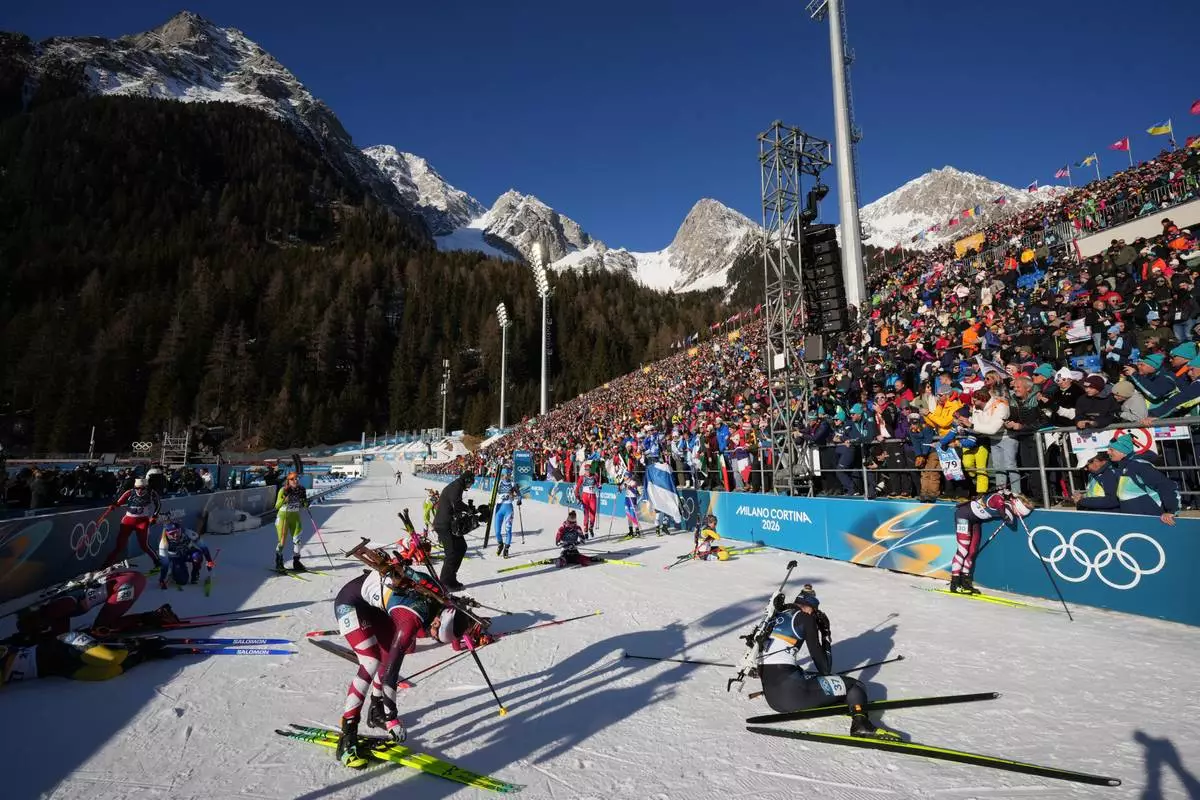 Athletes react in the finish area after the women's 10-kilometer pursuit biathlon race at the 2026 Winter Olympics in Anterselva, Italy, Sunday, Feb. 15, 2026. (AP Photo/Andrew Medichini)