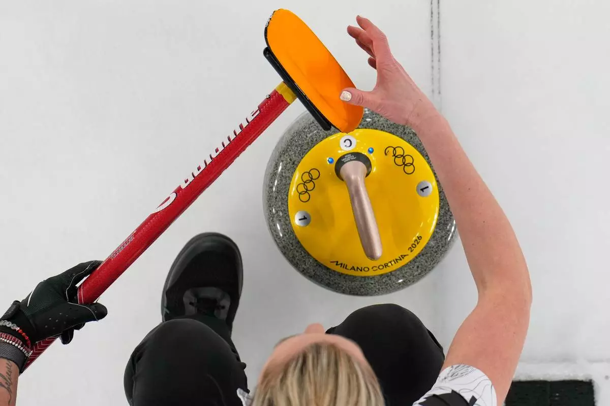 Canada's Emma Miskew prepares to deliver the stone during a women's curling round robin match against China at the 2026 Winter Olympics, in Cortina d'Ampezzo, Italy, Monday, Feb. 16, 2026. (AP Photo/David J. Phillip)