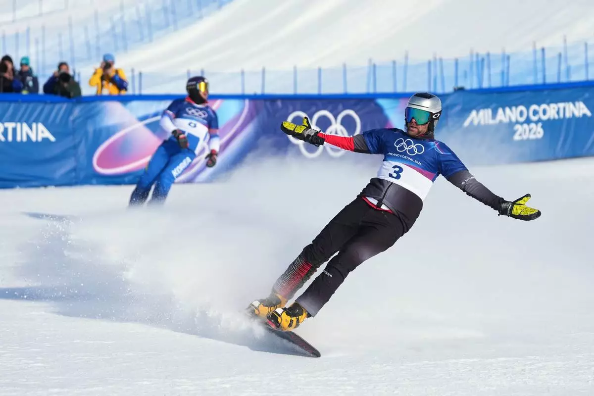 Austria's Benjamin Karl celebrates winning the gold medal against South Korea's Kim Sang-kyum in the men's snowboarding parallel giant slalom finals at the 2026 Winter Olympics, in Livigno, Italy, Sunday, Feb. 8, 2026. (AP Photo/Lindsey Wasson)