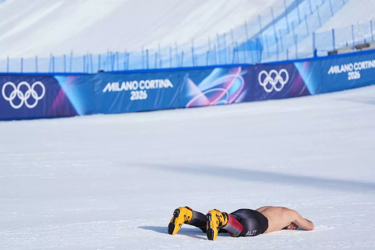 Austria's Benjamin Karl celebrates winning the gold medal in the men's snowboarding parallel giant slalom finals at the 2026 Winter Olympics, in Livigno, Italy, Sunday, Feb. 8, 2026. (AP Photo/Lindsey Wasson)