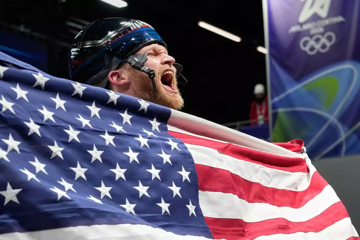 United States' Austin Florian reacts as he arrives at the finish during a men's skeleton run at the 2026 Winter Olympics, in Cortina d'Ampezzo, Italy, Friday, Feb. 13, 2026. (AP Photo/Alessandra Tarantino)