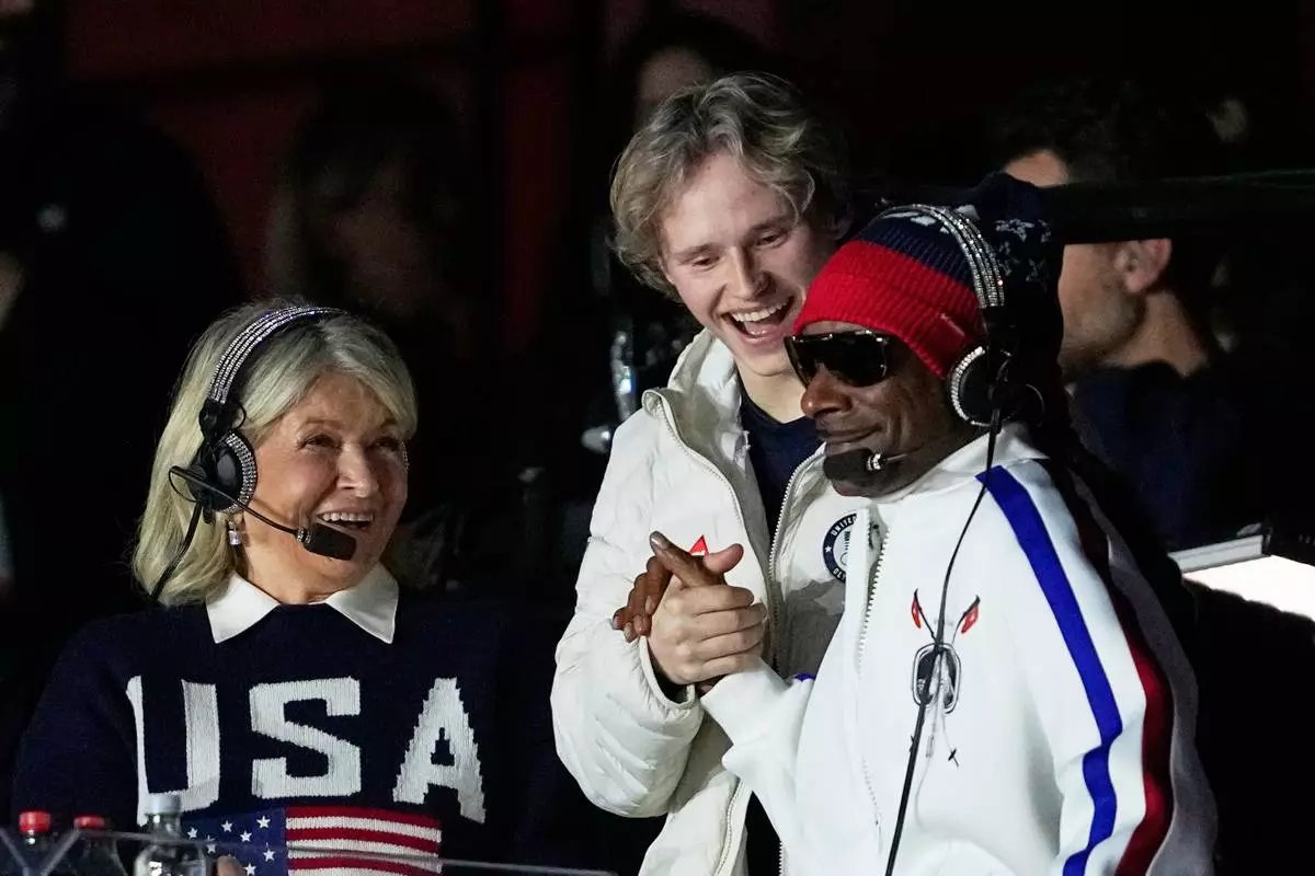 Martha Stewart, Ilia Malinin and Snoop Dog watch Amber Glenn of the United States during the women's short program figure skating at the 2026 Winter Olympics, in Milan, Italy, Tuesday, Feb. 17, 2026. (AP Photo/Ashley Landis)