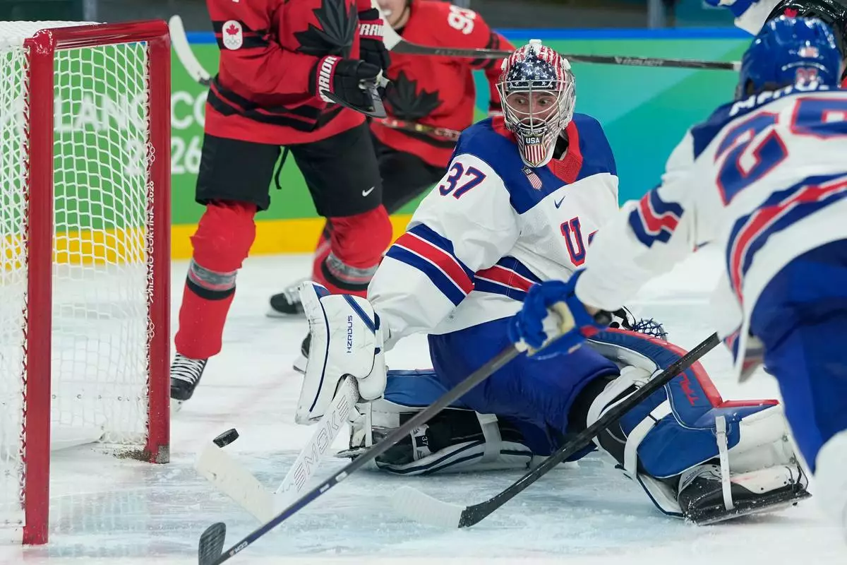 United States' Connor Hellebuyck (37) makes a stick save against Canada during the third period of a men's ice hockey gold medal game between Canada and the United States at the 2026 Winter Olympics, in Milan, Italy, Sunday, Feb. 22, 2026. (AP Photo/Petr David Josek)