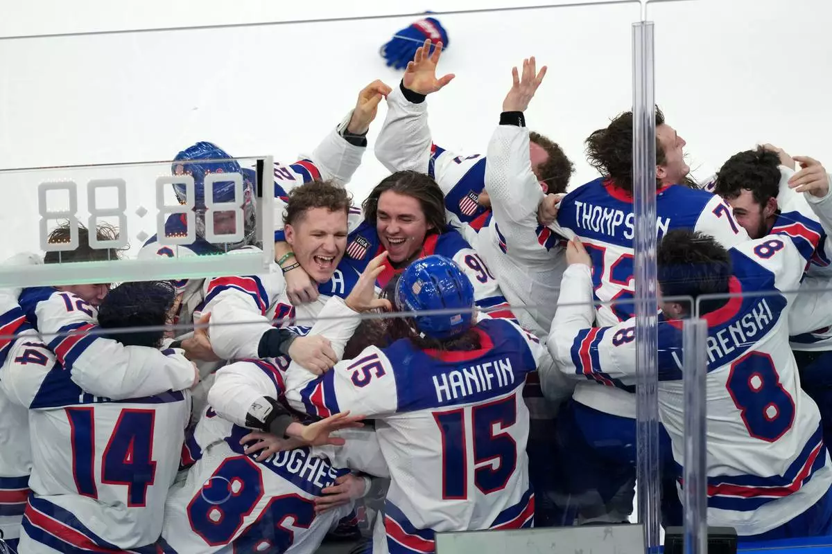 United States players celebrate after defeating Canada 2-1 in overtime to win the men's ice hockey gold medal game at the 2026 Winter Olympics in Milan, Italy, Sunday, Feb. 22, 2026. (AP Photo/Carolyn Kaster)