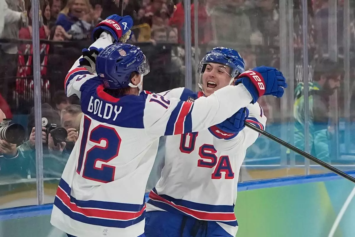United States' Matt Boldy, left, celebrates after scoring the opening goal during a men's ice hockey gold medal game between Canada and the United States at the 2026 Winter Olympics, in Milan, Italy, Sunday, Feb. 22, 2026. (AP Photo/Hassan Ammar)