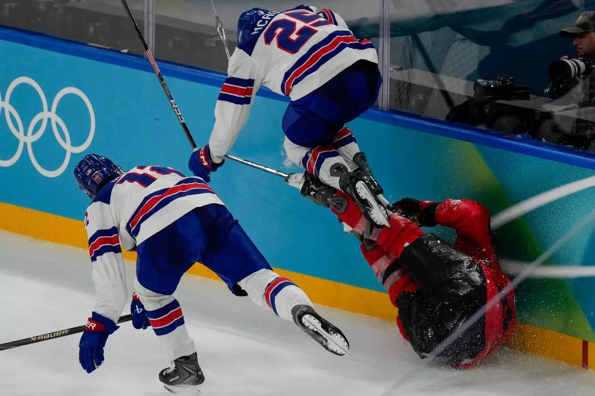 United States' Charlie McAvoy (25) leaps over Canada's Tom Wilson (43) during the second period of the men's ice hockey gold medal game at the 2026 Winter Olympics, in Milan, Italy, Sunday, Feb. 22, 2026. (AP Photo/Luca Bruno)