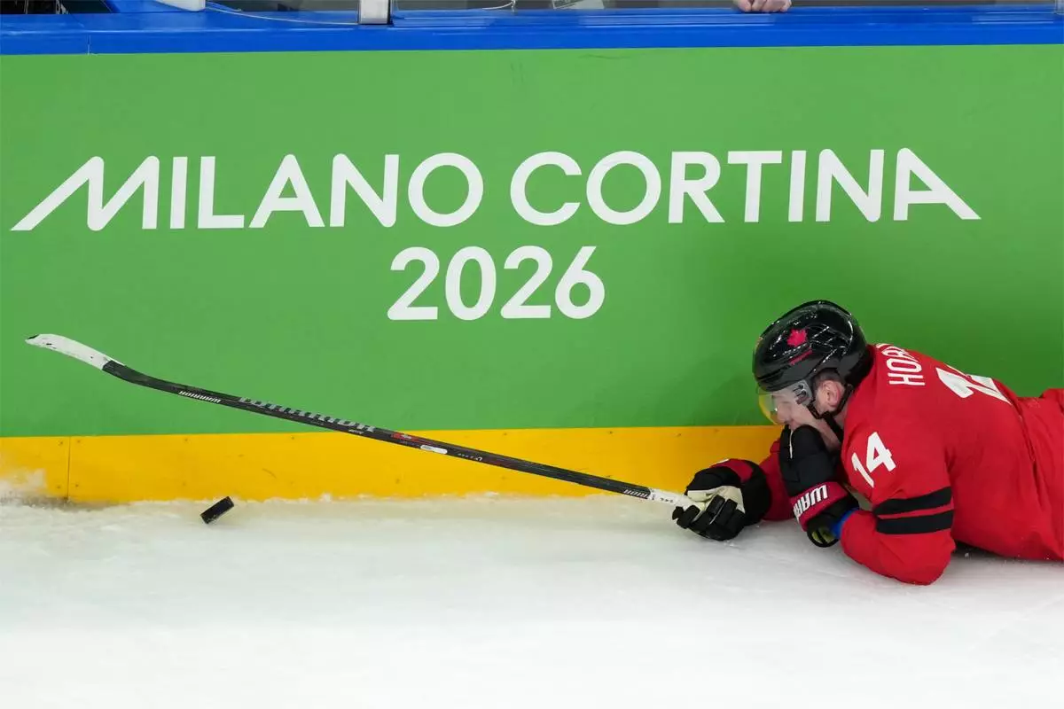 Canada's Bo Horvat falls after being hit with a high stick during the third period of the men's ice hockey gold medal game between Canada and the United States at the 2026 Winter Olympics in Milan, Italy, Sunday, Feb. 22, 2026. (AP Photo/Carolyn Kaster)