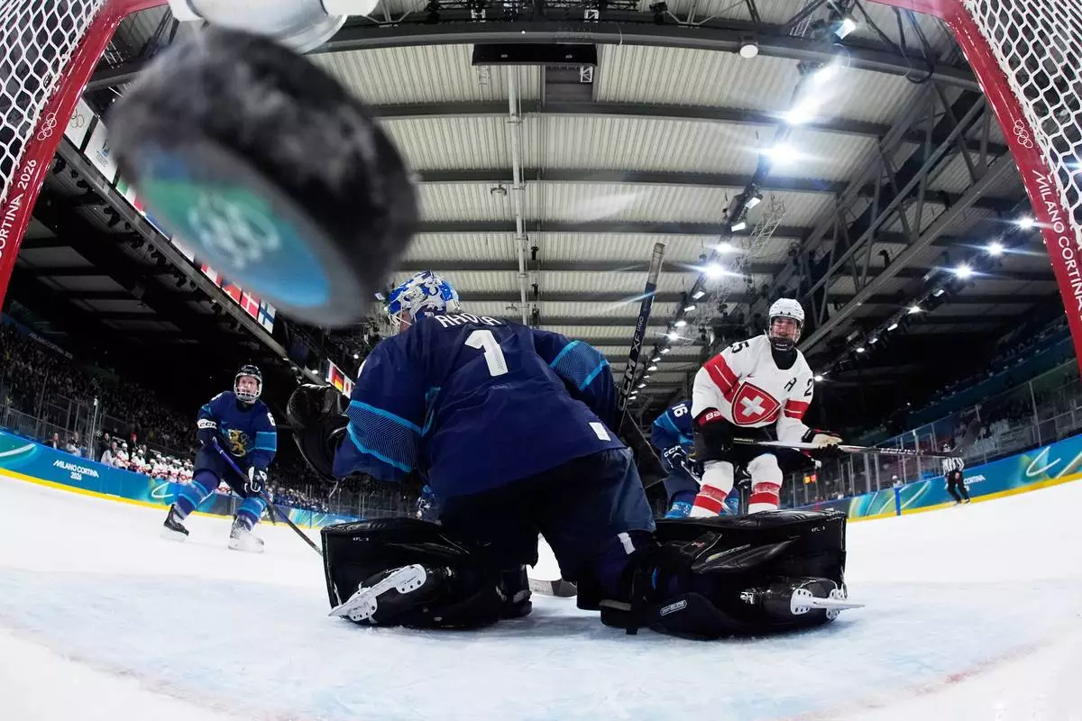 Switzerland's Alina Muller scores her side's opening goal during a preliminary round match of women's ice hockey between Finland and Switzerland at the 2026 Winter Olympics, in Milan, Italy, Tuesday, Feb. 10, 2026. (AP Photo/Darko Bandic, Pool)