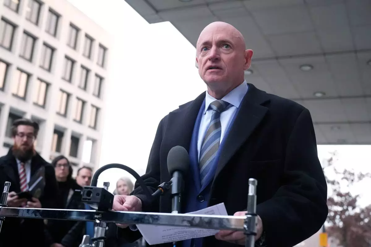 Sen. Mark Kelly, D-Ariz.,speaks to reporters outside of federal court in Washington, Tuesday, Feb. 3, 2026. (AP Photo/Mark Schiefelbein)