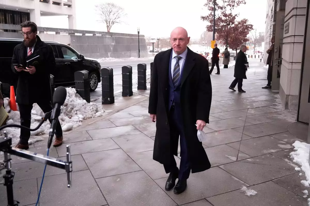Sen. Mark Kelly, D-Ariz.,walks to speak to reporters outside of federal court in Washington, Tuesday, Feb. 3, 2026. (AP Photo/Mark Schiefelbein)
