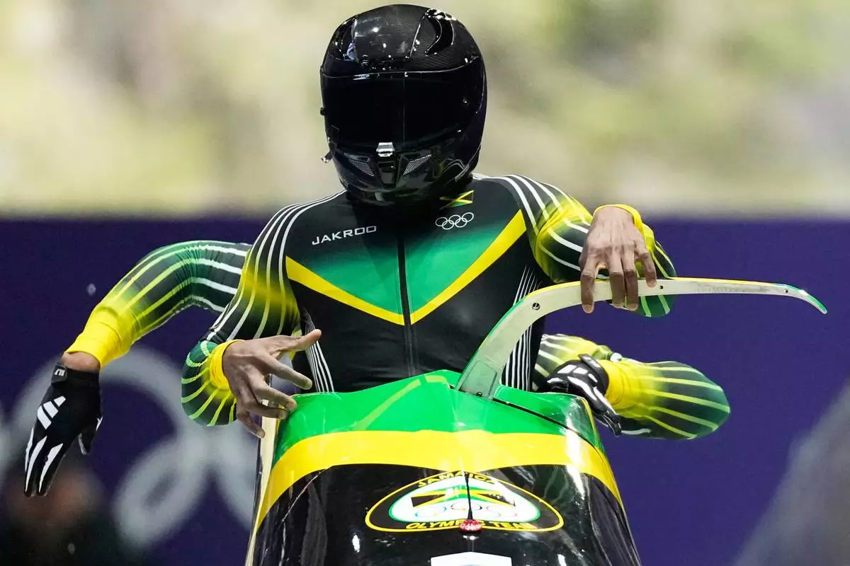 Jamaica's Shane Pitter, front, and Junior Harris start for a two man bobsled run at the 2026 Winter Olympics, in Cortina d'Ampezzo, Italy, Monday, Feb. 16, 2026. (AP Photo/Alessandra Tarantino)
