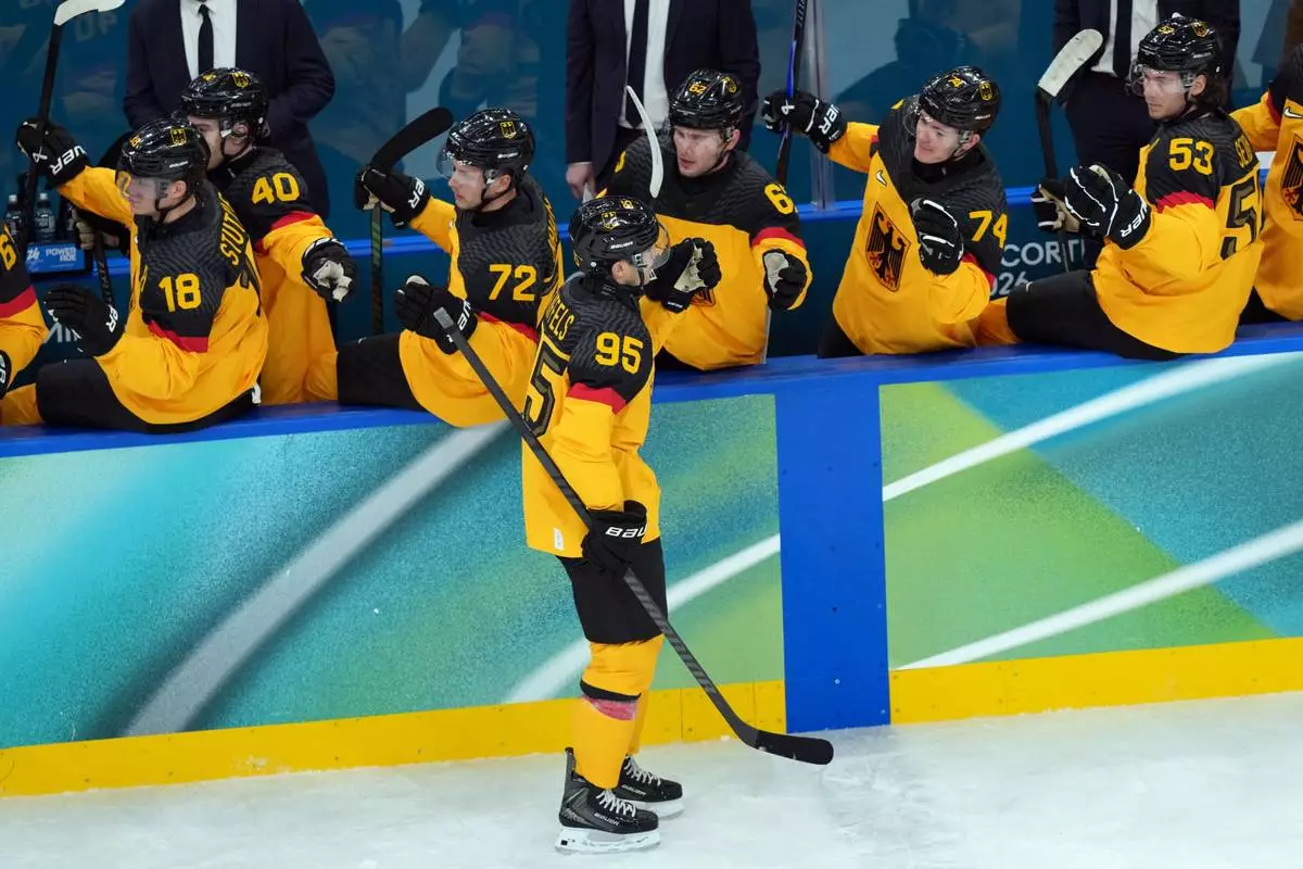 Germany's Frederik Tiffels (95) is congratulated after scoring a goal against France during the first period of a men's ice hockey qualification playoff game at the 2026 Winter Olympics, in Milan, Italy, Tuesday, Feb. 17, 2026. (AP Photo/Carolyn Kaster)