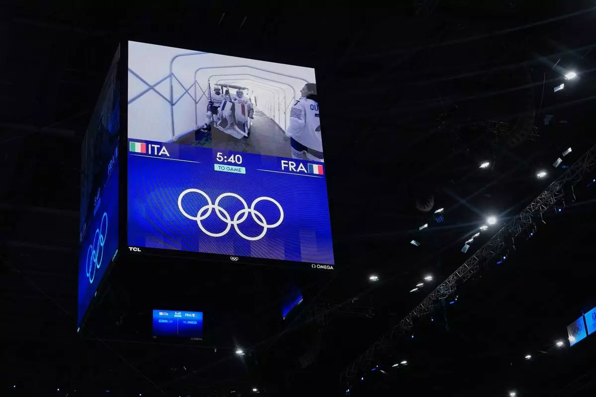 France's goalkeepers displayed on the scoreboard screen being carted to the rink before a preliminary round women's ice hockey match against Italy, at the 2026 Winter Olympics, in Milan, Italy, Thursday, Feb. 5, 2026. (AP Photo/Carolyn Kaster)