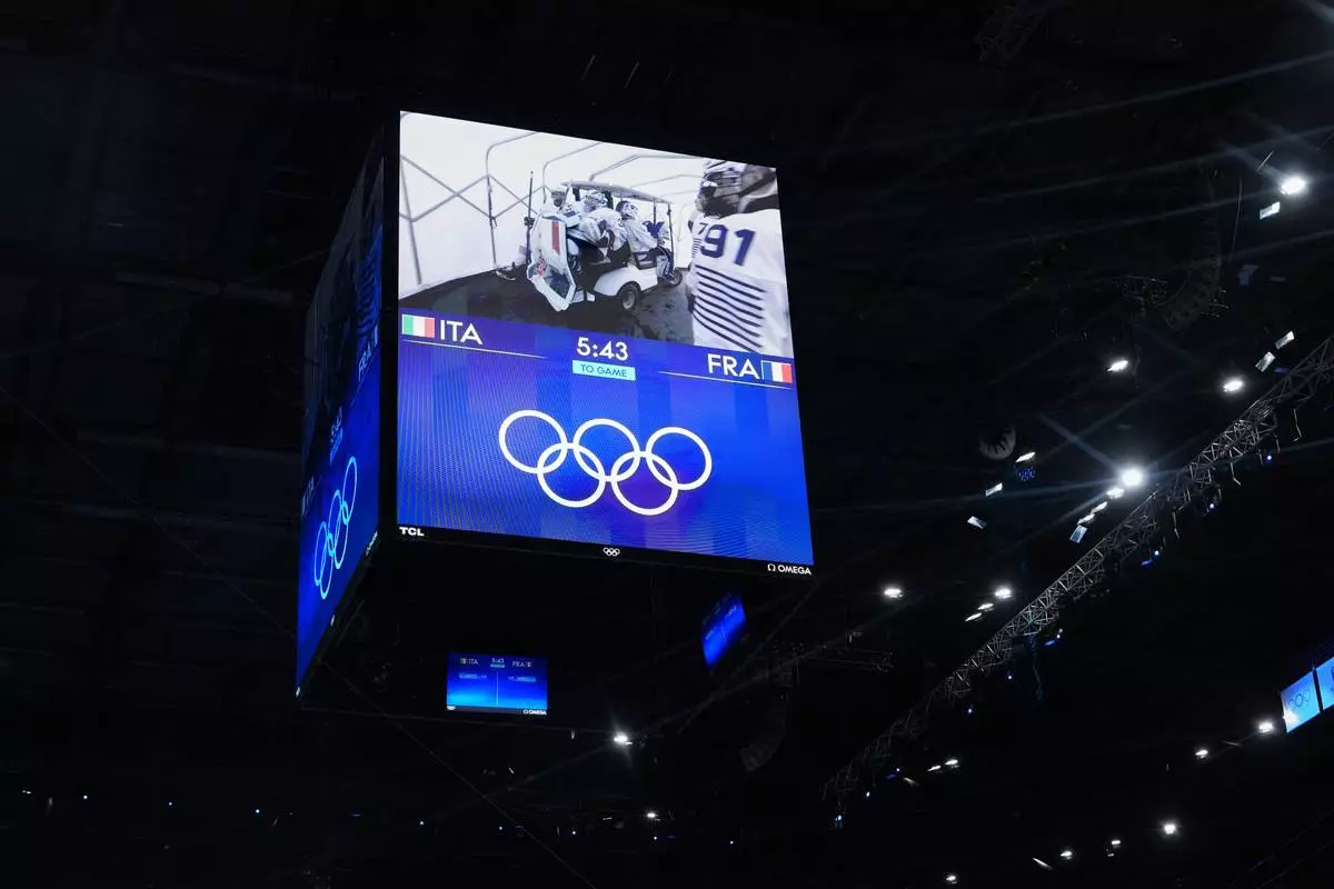 France's goalkeepers displayed on the scoreboard screen being carted to the rink before a preliminary round women's ice hockey match against Italy, at the 2026 Winter Olympics, in Milan, Italy, Thursday, Feb. 5, 2026. (AP Photo/Carolyn Kaster)