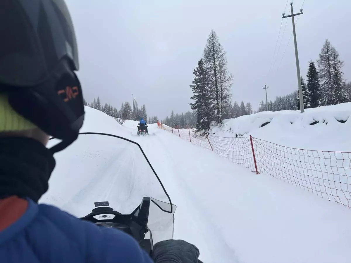 Associated Press video journalist Brittany Peterson drives a snowmobile during a tour to the Three Peaks of Lavaredo, Thursday, Feb. 5, 2026. The Cortina company Snowdreamers and Uber partnered to offer free snowmobiling tours on the weekends in February to people in town for the 2026 Winter Olympic Games. (AP Photo/Jennifer McDermott)