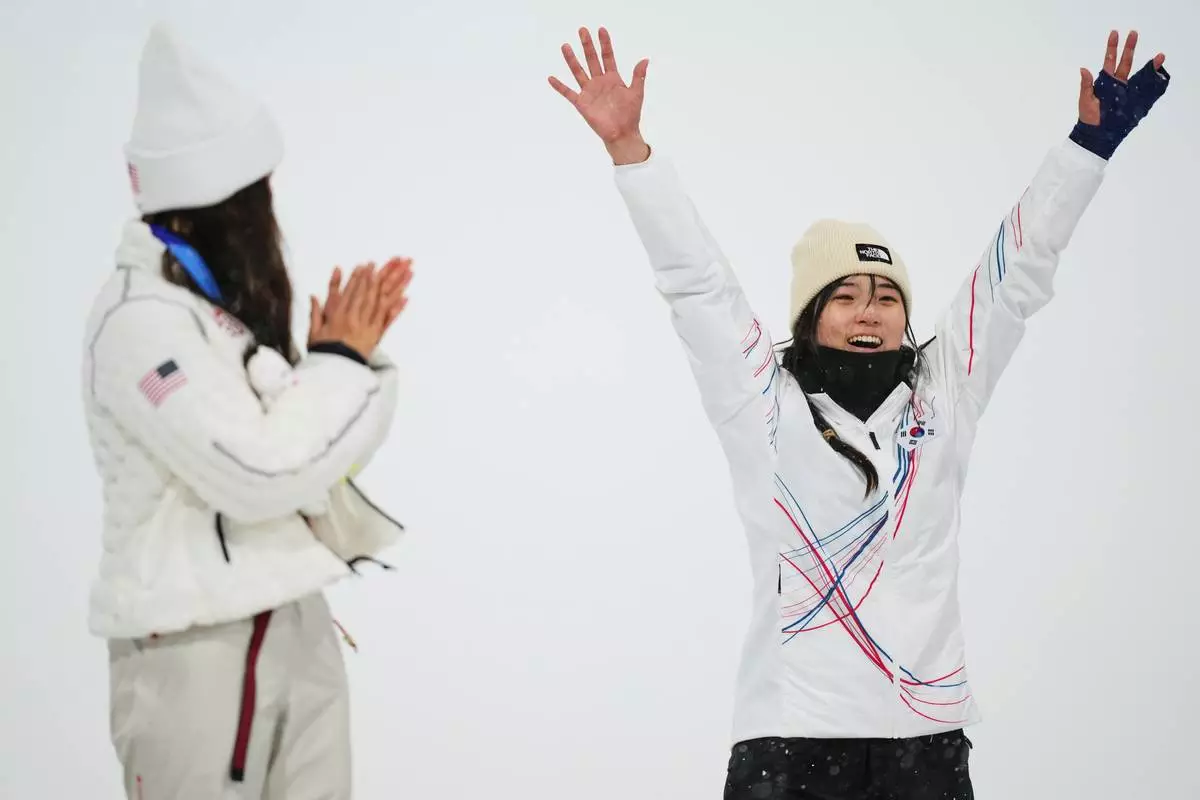 Silver medalist United States' Chloe Kim, left, claps as gold medalist South Korea's Choi Ga-on celebrates winning the the women's snowboarding halfpipe finals at the 2026 Winter Olympics, in Livigno, Italy, Thursday, Feb. 12, 2026. (AP Photo/Abbie Parr)