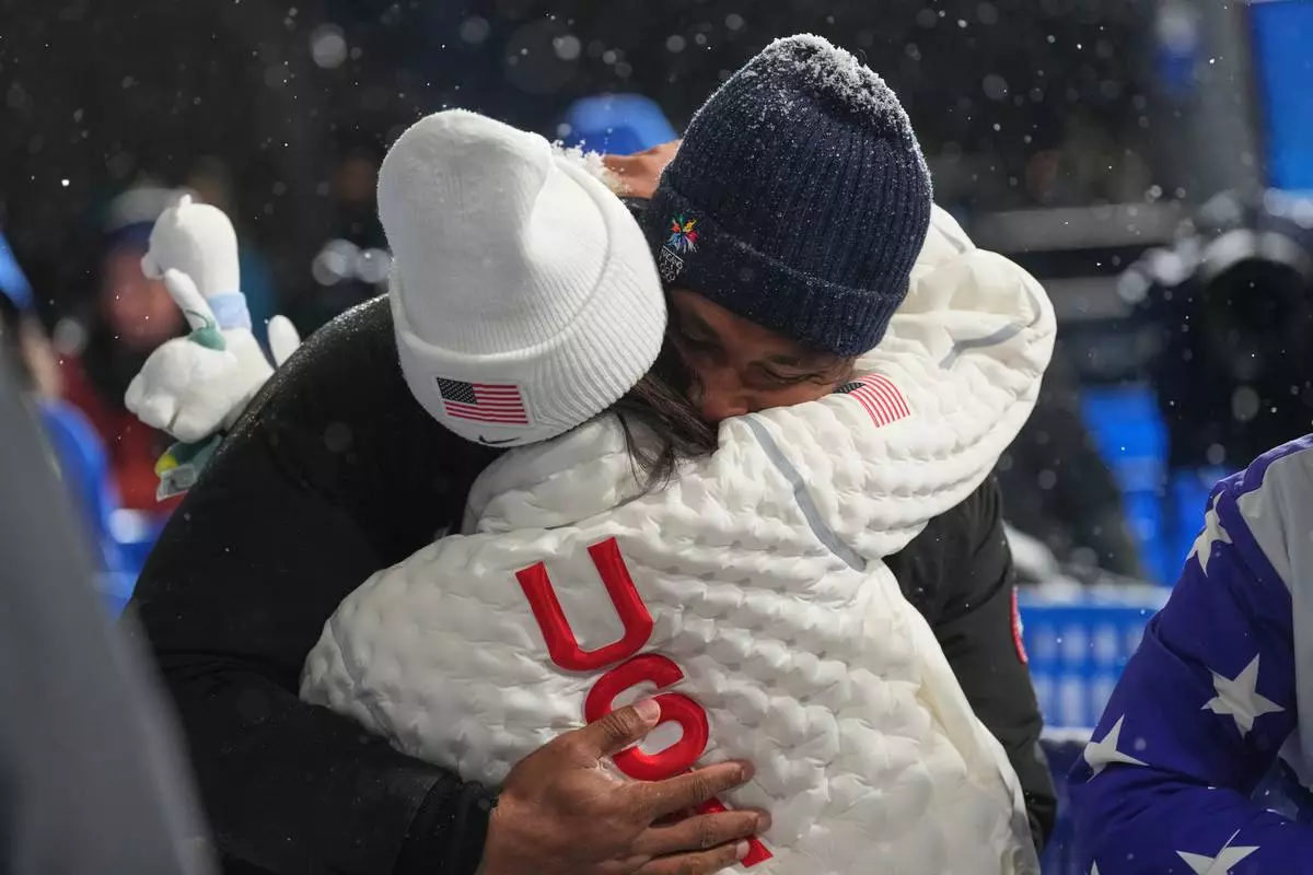 United States' Chloe Kim and Cleveland Browns' Myles Garrett hug after Kim won the silver medal in the women's snowboarding halfpipe finals at the 2026 Winter Olympics, in Livigno, Italy, Thursday, Feb. 12, 2026. (AP Photo/Lindsey Wasson)