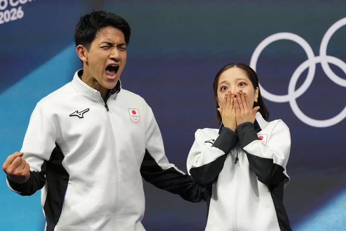 Riku Miura and Ryuichi Kihara of Japan react to their scores after competing during the pairs figure skating long program at the 2026 Winter Olympics, in Milan, Italy, Monday, Feb. 16, 2026. (AP Photo/Francisco Seco)