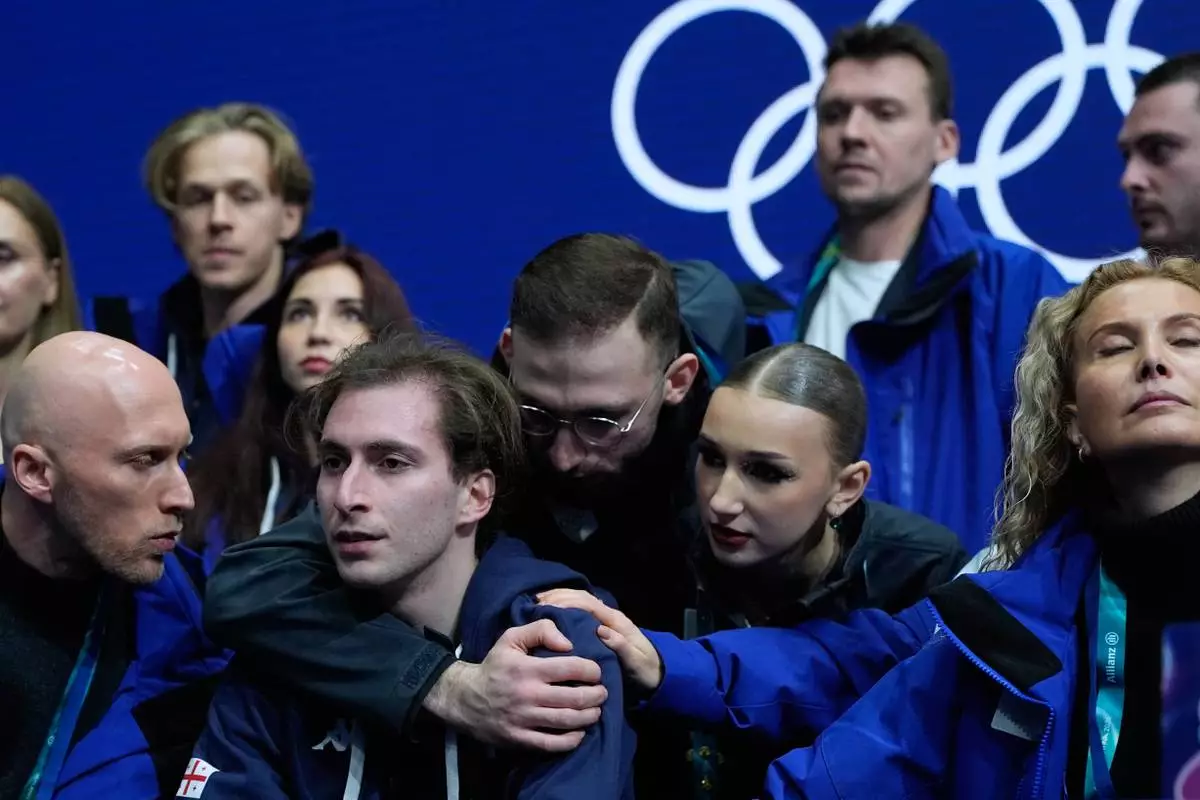 Nika Egadze of Georgia reacts to his scores after competing during the figure skating men's team event at the 2026 Winter Olympics, in Milan, Italy, Sunday, Feb. 8, 2026. (AP Photo/Ashley Landis)