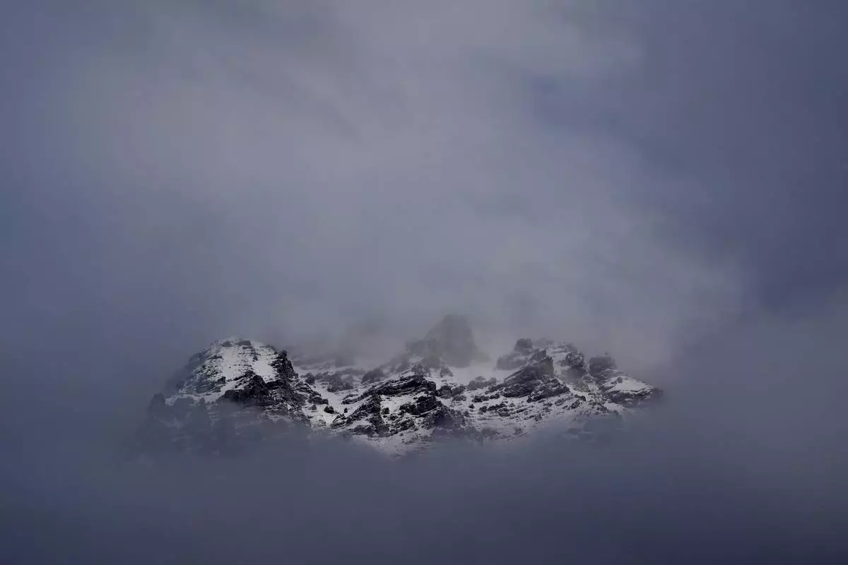 The peaks towards the Stelvio Pass are seen through the clouds ahead of of an alpine ski, men's super-G race, at the 2026 Winter Olympics, in Bormio, Italy, Wednesday, Feb. 11, 2026. (AP Photo/Rebecca Blackwell)