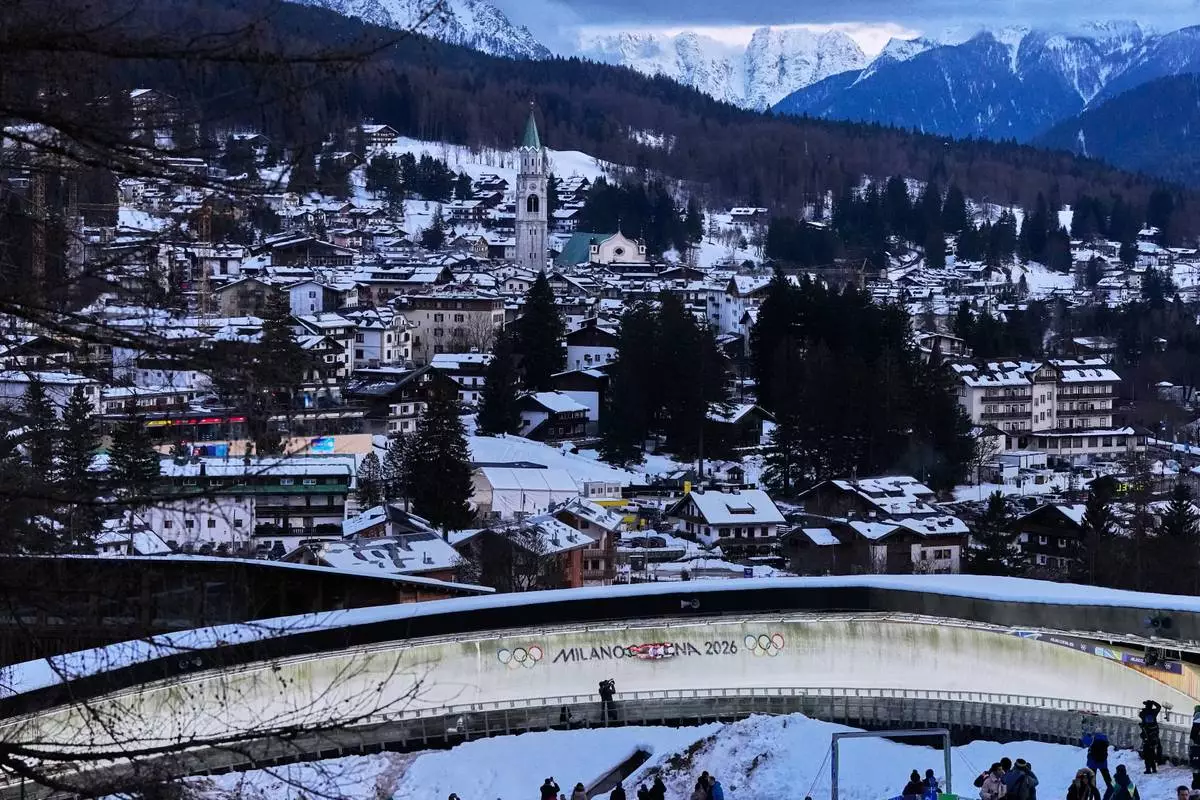 Canada's Beattie Podulsky, left, and Kailey Allan, right, slide down the track during a women's doubles luge run at the 2026 Winter Olympics, in Cortina d'Ampezzo, Italy, Wednesday, Feb. 11, 2026. (AP Photo/Alessandra Tarantino)