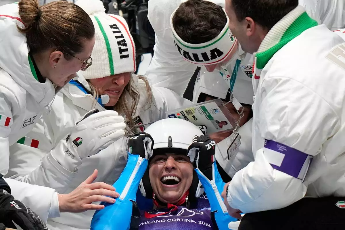 Italy's gold medalists Andrea Voetter and Marion Oberhofer celebrate as they arrive at the finish during a women's doubles luge run at the 2026 Winter Olympics, in Cortina d'Ampezzo, Italy, Wednesday, Feb. 11, 2026. (AP Photo/Aijaz Rahi)