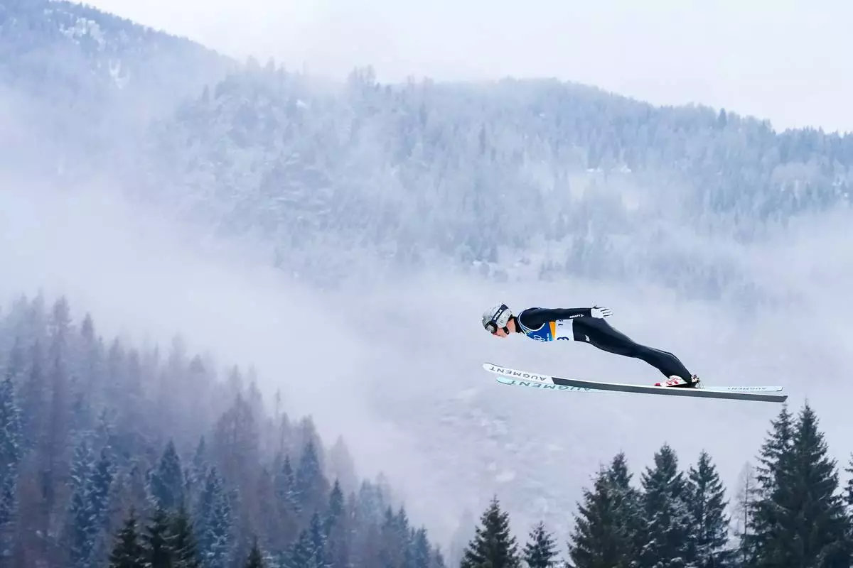 Marco Heinis, of France, soars through the air during the Nordic Combined Individual Gundersen Normal Hill/10km competition at the 2026 Winter Olympics, in Predazzo, Italy, Wednesday, Feb. 11, 2026. (AP Photo/Kirsty Wigglesworth)