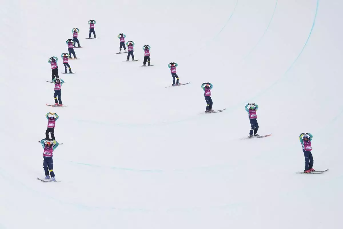 Workers prep the halfpipe before the women's snowboarding halfpipe qualifications at the 2026 Winter Olympics, in Livigno, Italy, Wednesday, Feb. 11, 2026. (AP Photo/Lindsey Wasson)
