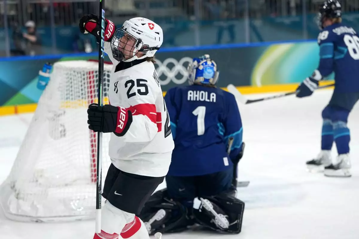 Switzerland's Alina Muller (25) celebrates after scoring against Finland goalkeeper Sanni Ahola (1) during the second period of a women's ice hockey quarterfinal match at the 2026 Winter Olympics, in Milan, Italy, Saturday, Feb. 14, 2026. (AP Photo/Carolyn Kaster)