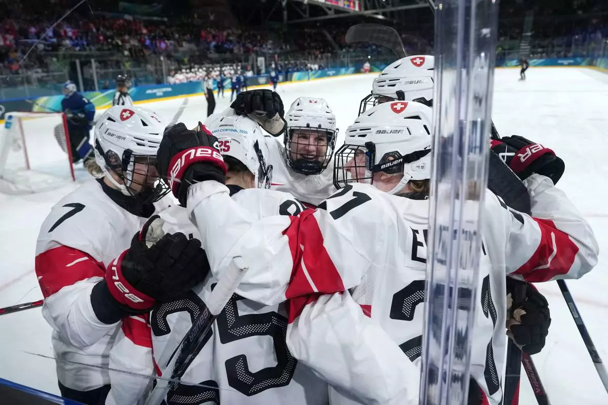 Switzerland's Alina Muller (25) is congratulated after scoring a goal against Finland during the second period of a women's ice hockey quarterfinal match at the 2026 Winter Olympics, in Milan, Italy, Saturday, Feb. 14, 2026. (AP Photo/Carolyn Kaster)