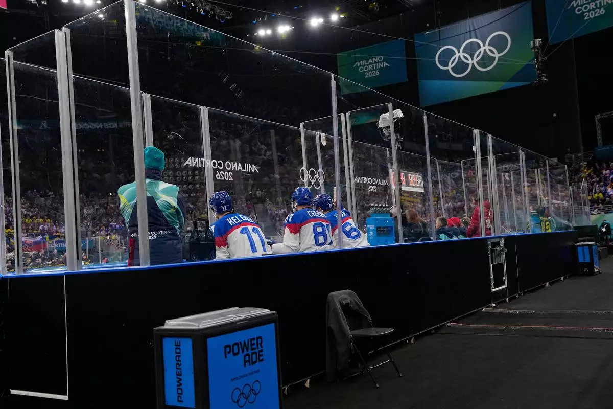 Slovakia's Milos Kelemen, left, Slovakia's Erik Cernak, center, and Slovakia's Patrik Koch sit in the penalty box during a preliminary round match of men's ice hockey between Sweden and Slovakia at the 2026 Winter Olympics, in Milan, Italy, Saturday, Feb. 14, 2026. (AP Photo/Petr David Josek)