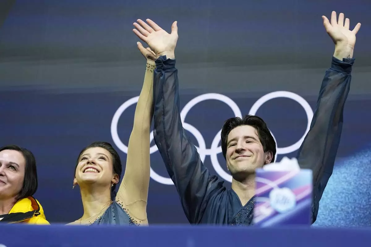 Anastasiia Golubeva and Hektor Giotopoulos Moore of Australia wait for scores after competing, during the pairs figure skating short program at the 2026 Winter Olympics, in Milan, Italy, Sunday, Feb. 15, 2026. (AP Photo/Natacha Pisarenko)