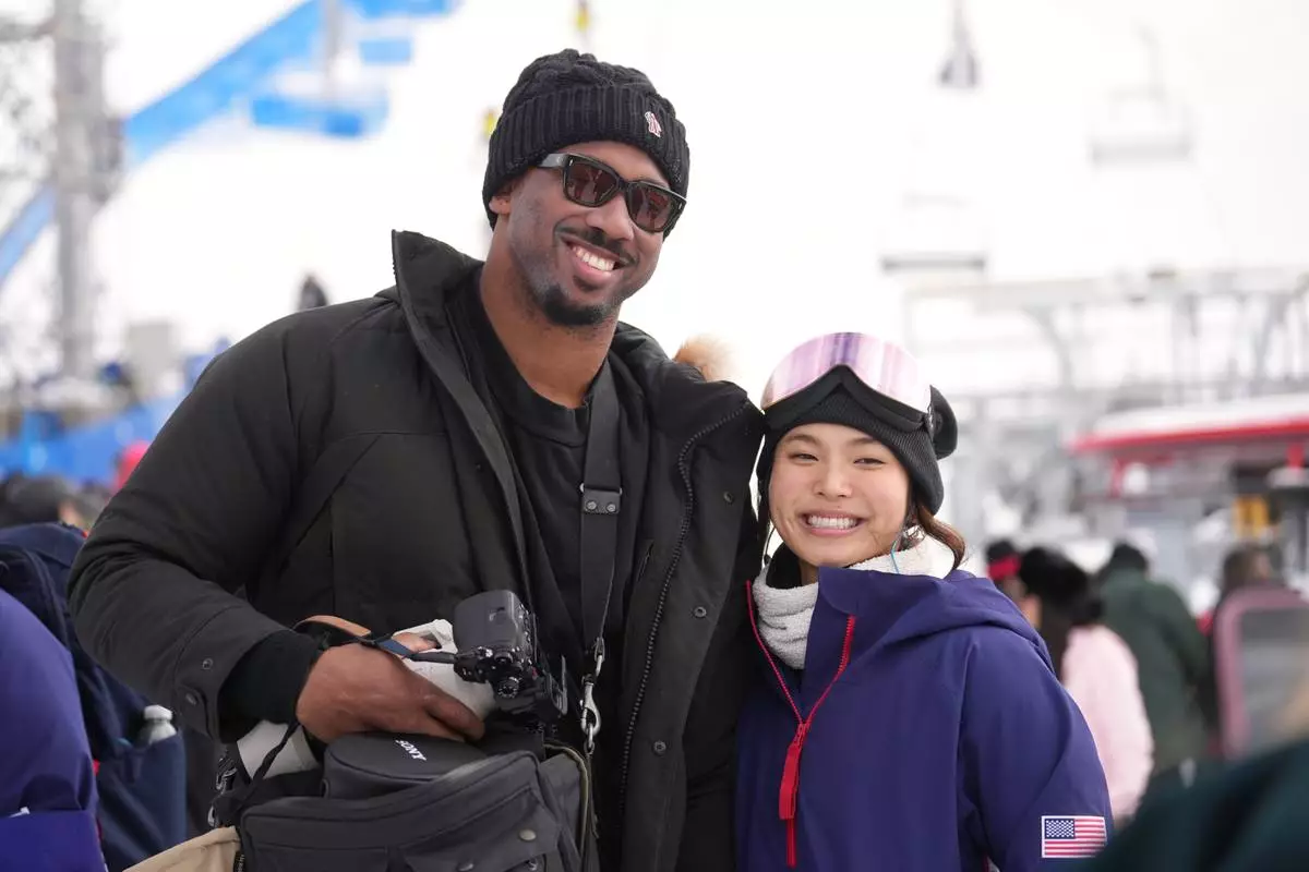 Cleveland Browns' Myles Garrett, left, and United States' Chloe Kim smile after the women's snowboarding halfpipe qualifications at the 2026 Winter Olympics, in Livigno, Italy, Wednesday, Feb. 11, 2026. (AP Photo/Lindsey Wasson)