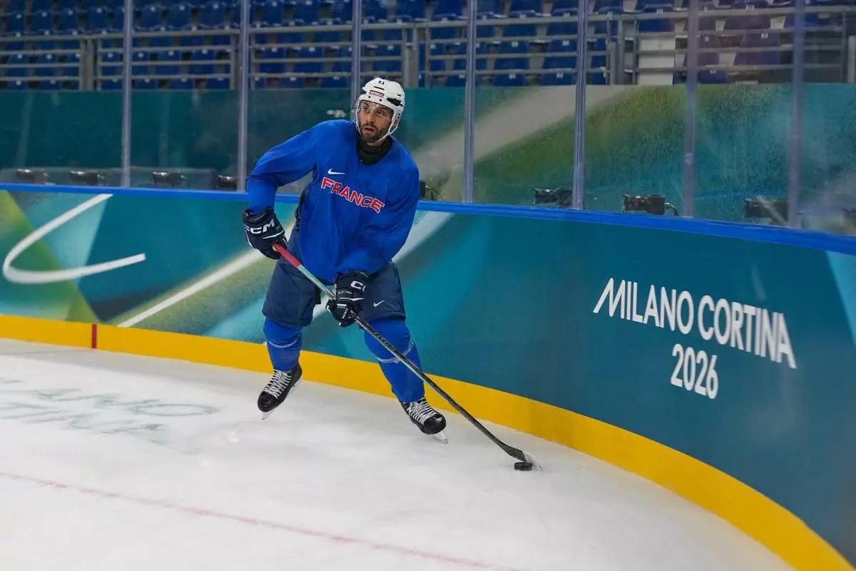 France's Pierre-Edouard Bellemare moves the puck during a training session prior to the 2026 Winter Olympics, in Milan, Italy, Wednesday, Feb. 4, 2026. (AP Photo/Hassan Ammar)