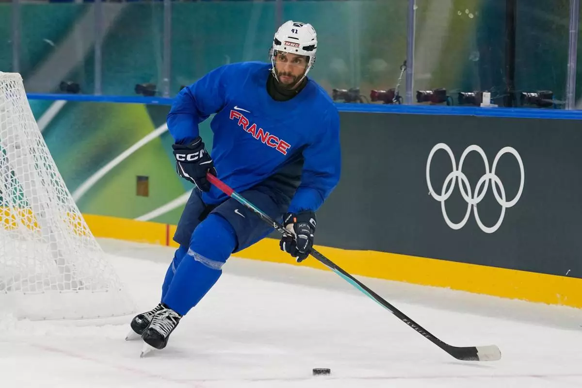 France's Pierre-Edouard Bellemare moves the puck during a training session prior to the 2026 Winter Olympics, in Milan, Italy, Wednesday, Feb. 4, 2026. (AP Photo/Hassan Ammar)